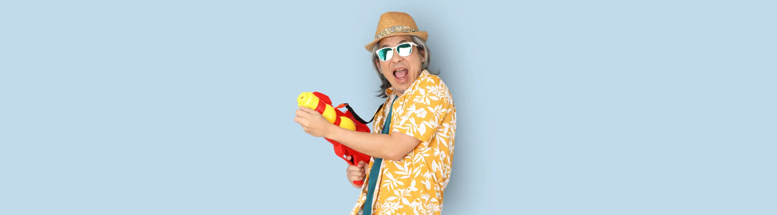 Senior asian man wearing summer clothes holding water gun