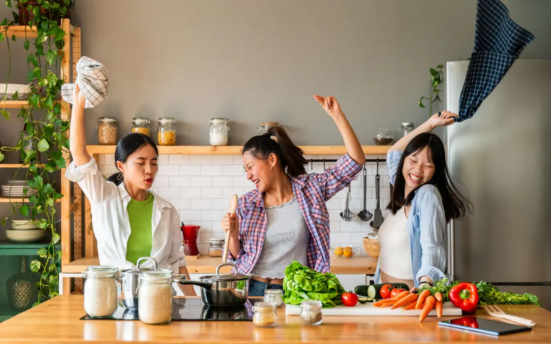 3 asian ladies bonding and having fun together in kitchen